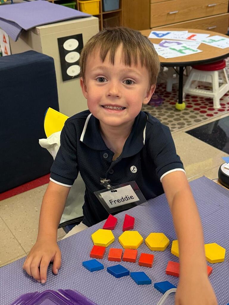 student at a table with math blocks