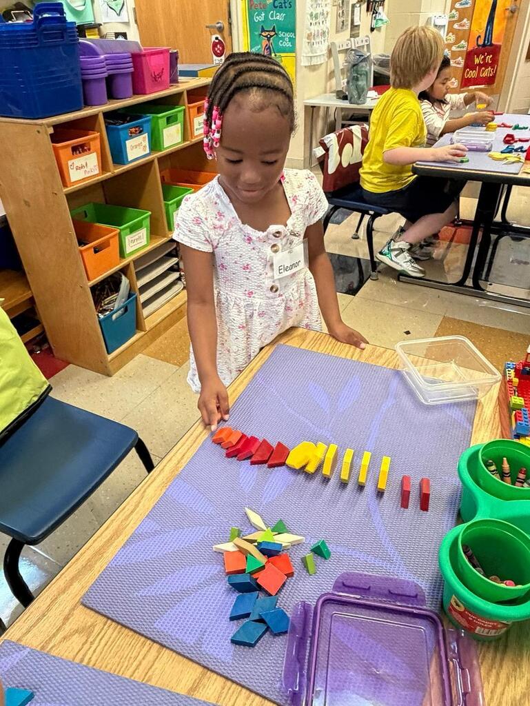 student at a table with math blocks