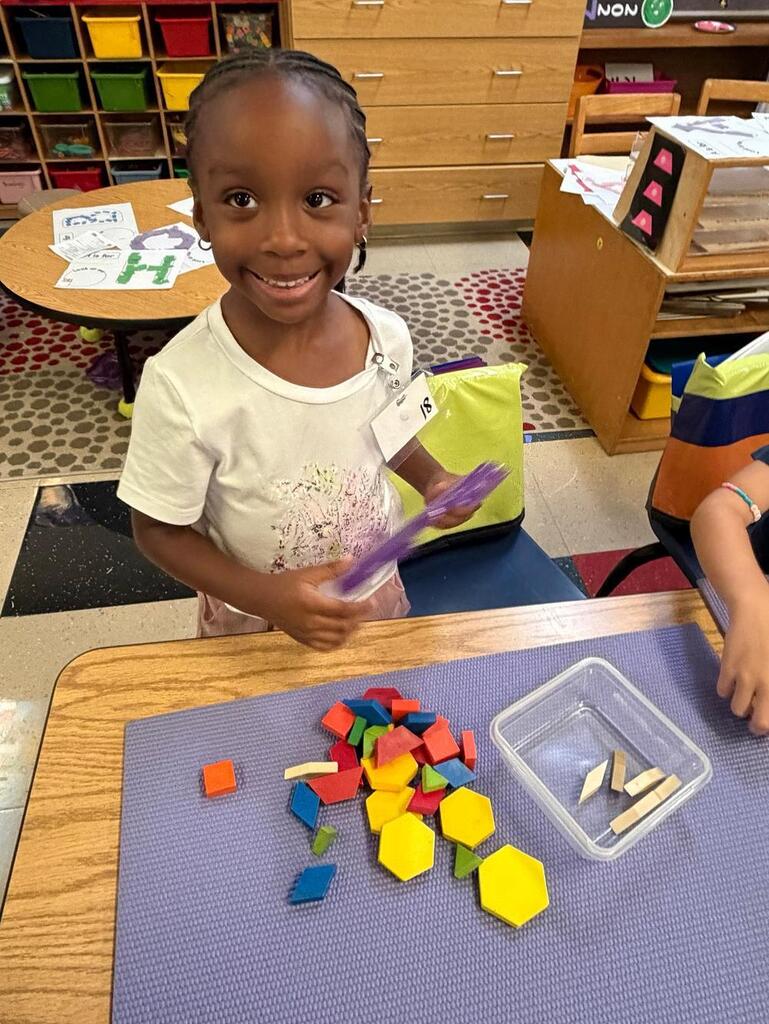 student at a table with math blocks