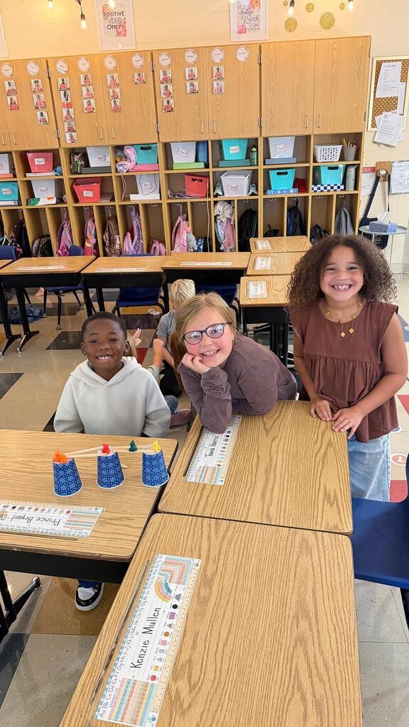 students sitting with cup and plastic bears 