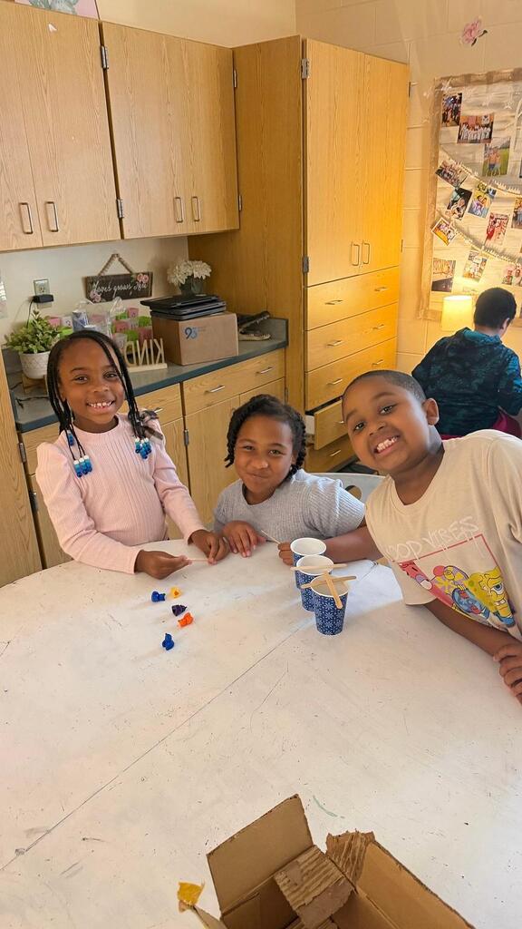 students sitting with cup and plastic bears 