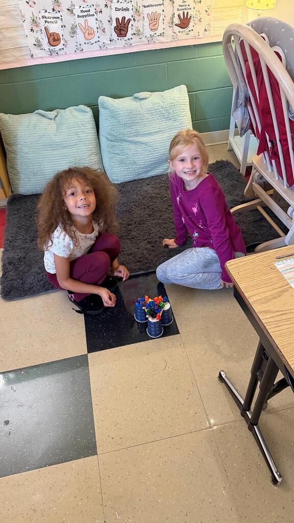 students sitting with cup and plastic bears 