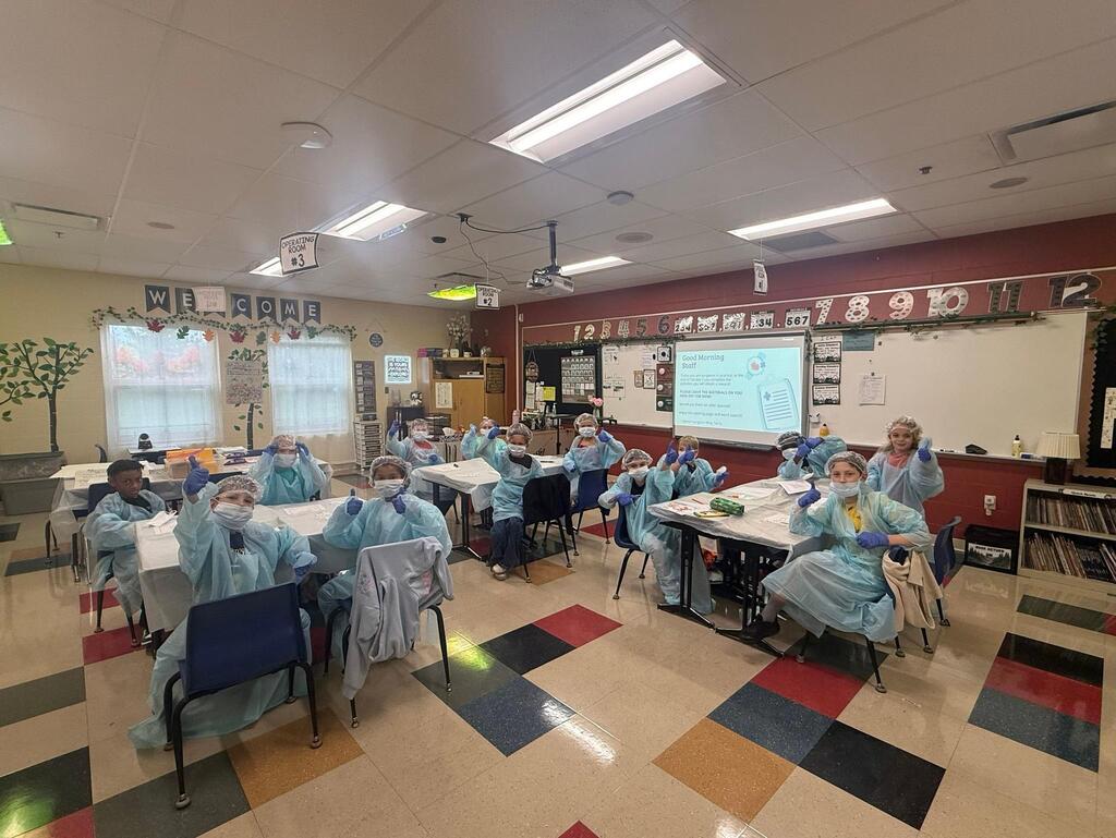 people in a classroom dressed in surgeon outfits