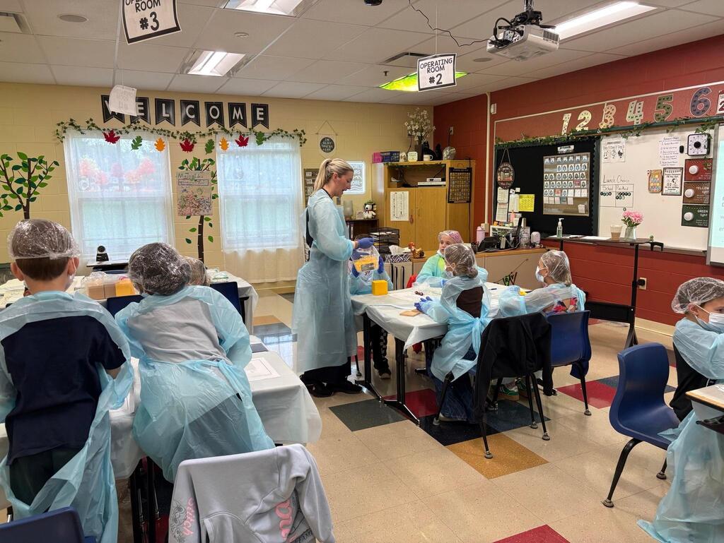 people in a classroom dressed in surgeon outfits
