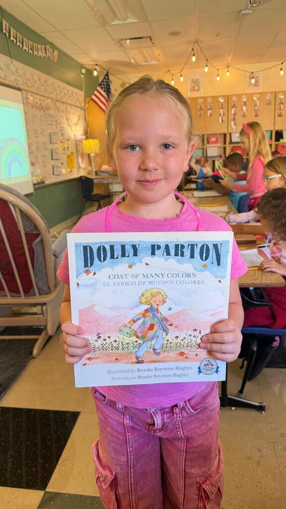student holding a book about Dolly Parton