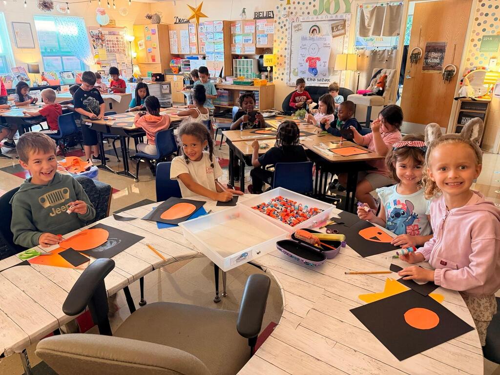 people holding pictures made of construction paper
