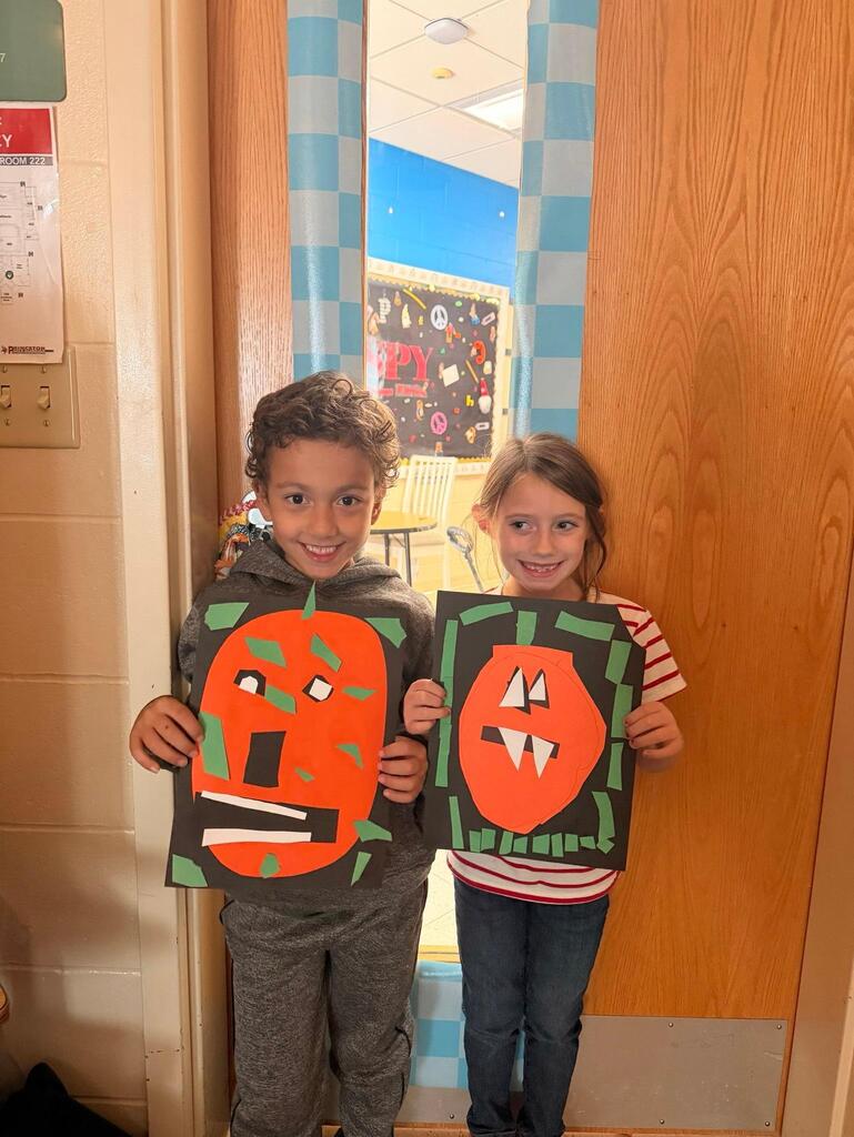 people holding pictures made of construction paper