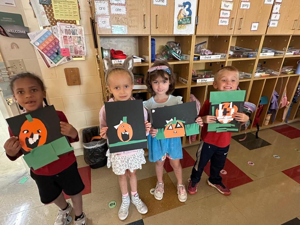 people holding pictures made of construction paper