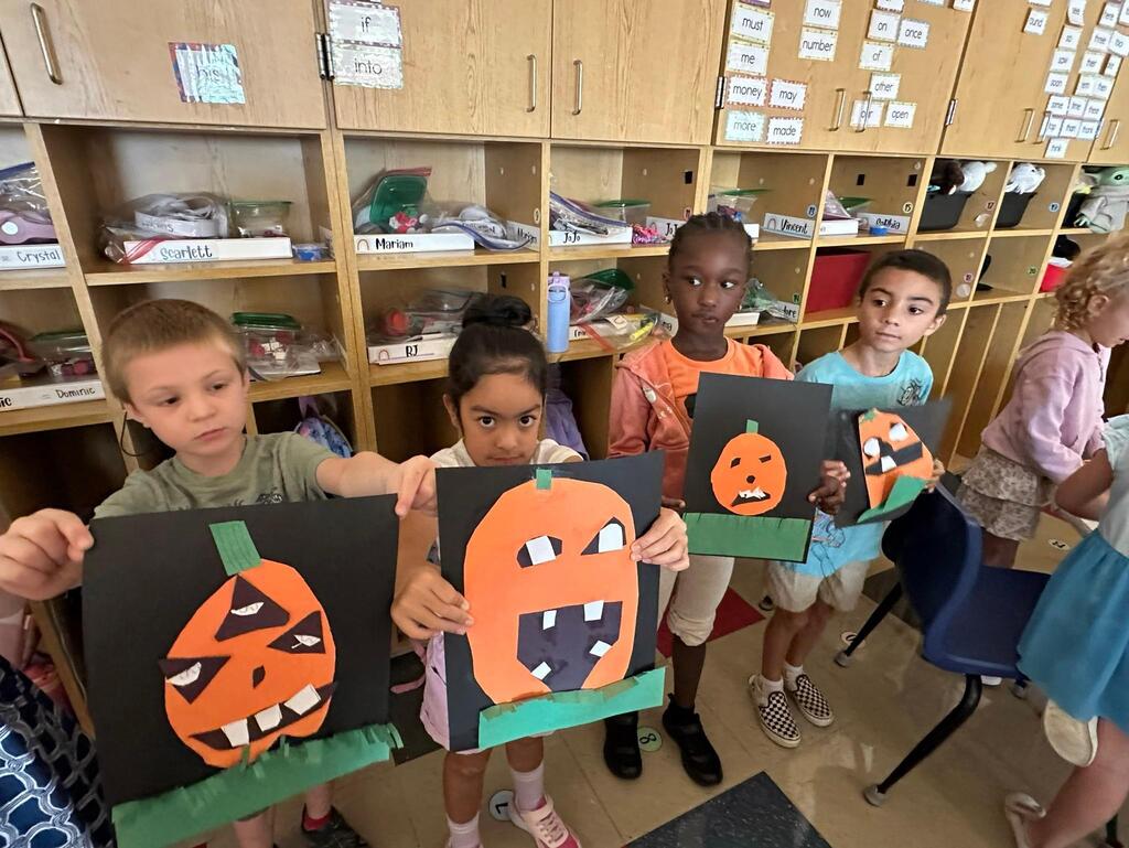 people holding pictures made of construction paper