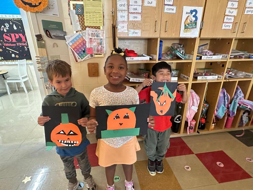 people holding pictures made from construction paper