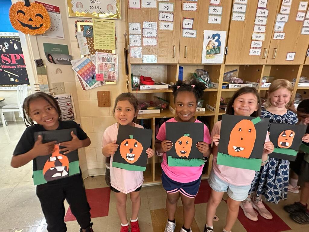 people holding pictures made of construction paper