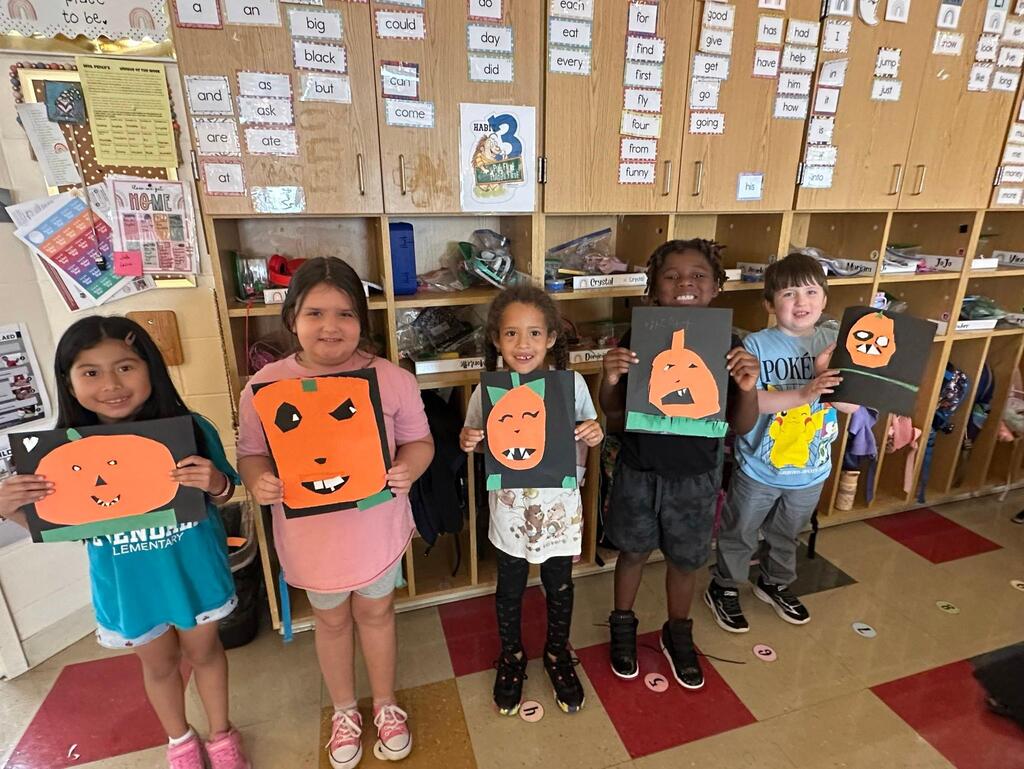 people holding pictures made of construction paper