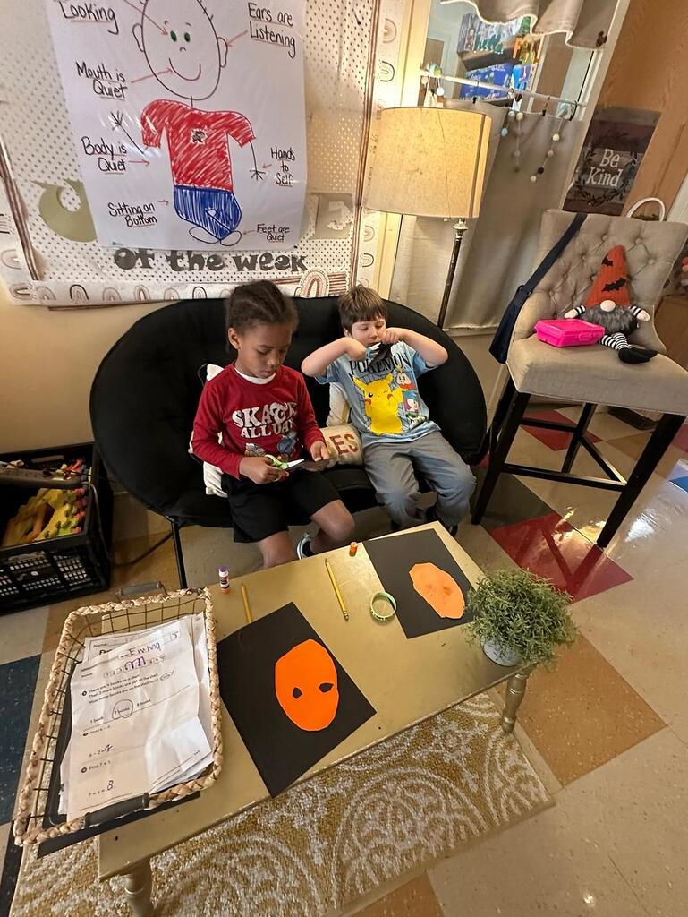people sitting making pictures with construction paper
