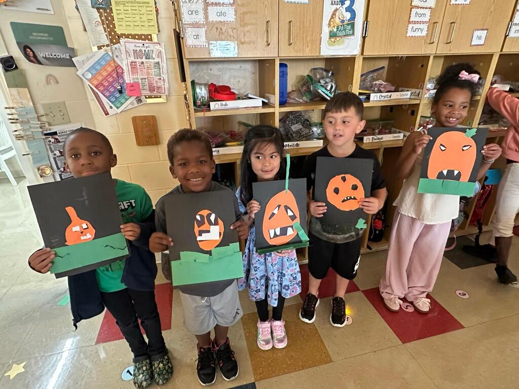 people holding pictures made of construction paper