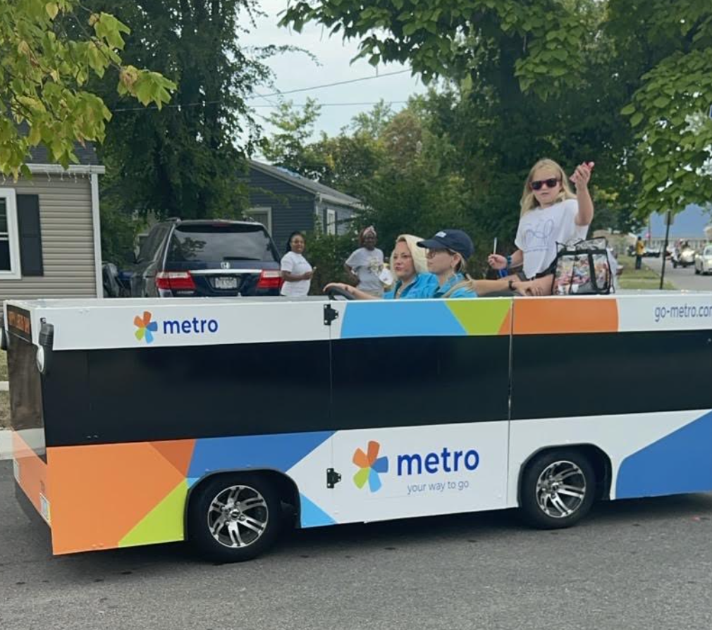 Mini Metro Bus in the Lincoln Heights Parade with student waving from top