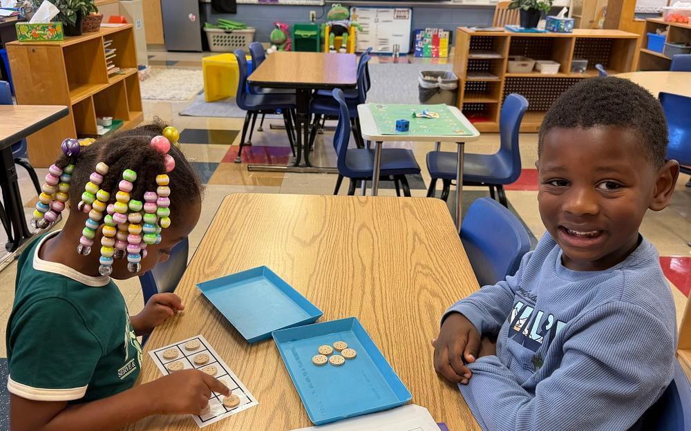 students at a table with math blocks 