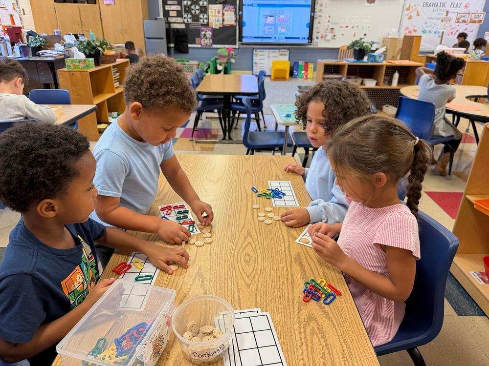 students at a table with math blocks 
