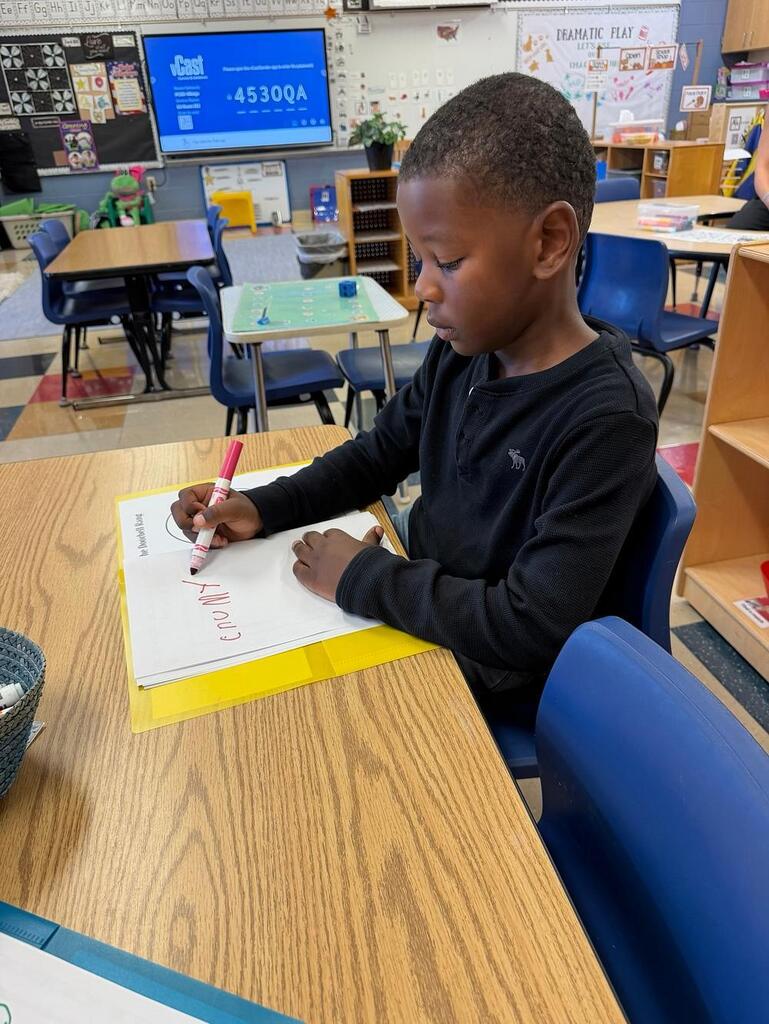 students at a table with writing items