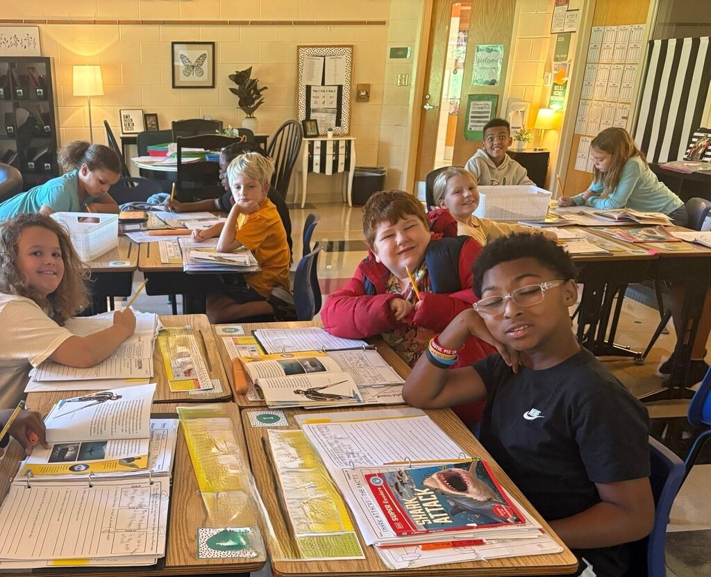 people sitting at desks with books and papers