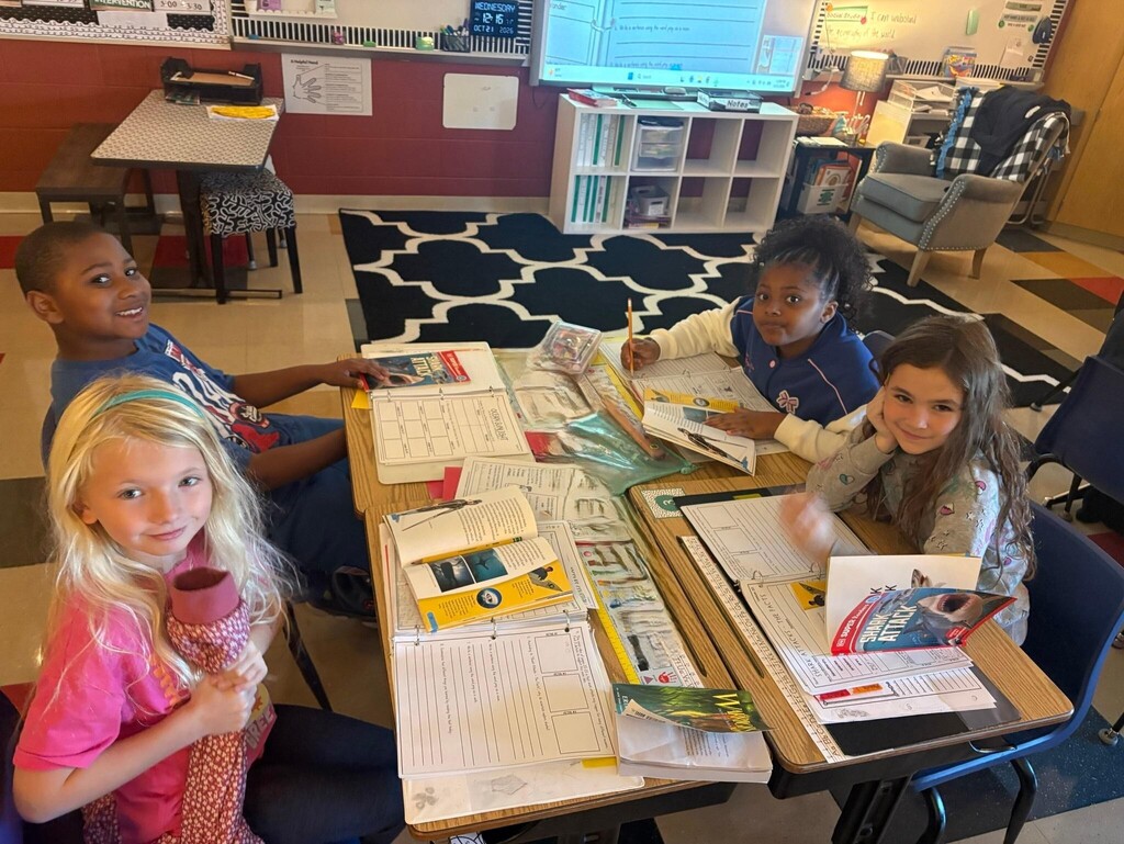 people sitting at desks with books and papers
