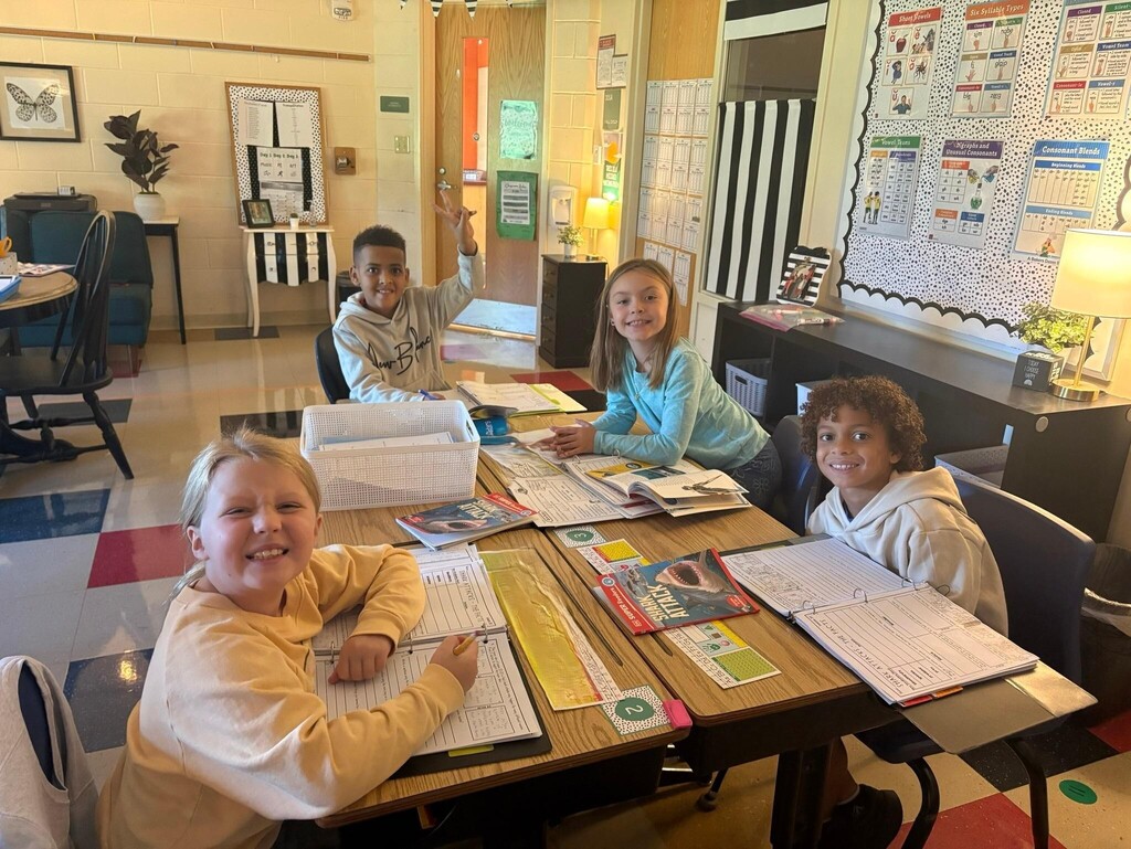 people sitting at desks with books and papers