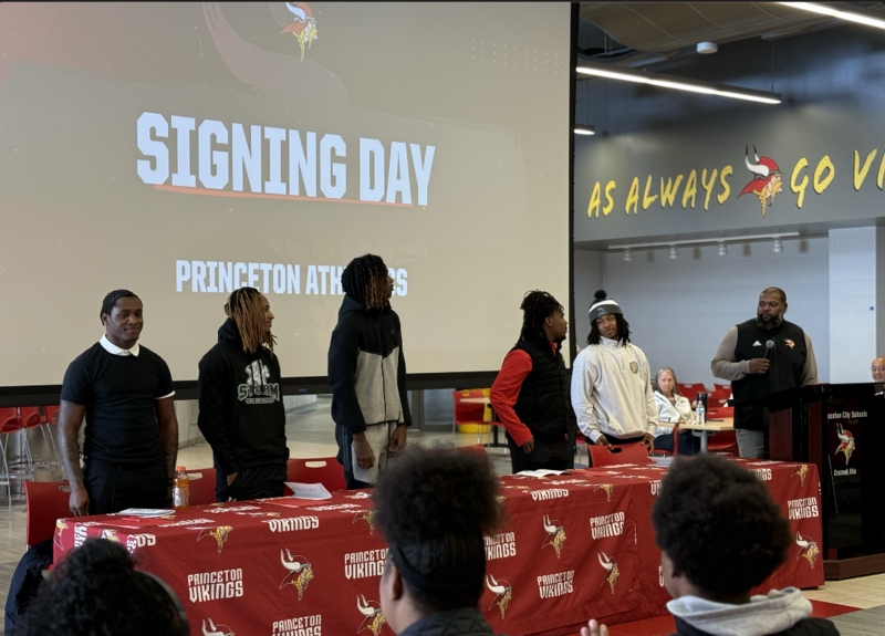 Signing Day athletes stand as Coach Andre Parker announces them as a group