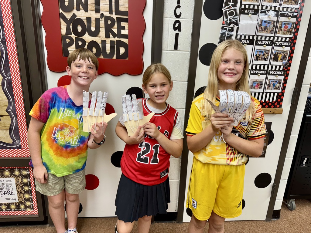 Students in Mrs. Dennison's class displaying model robot hands they created.