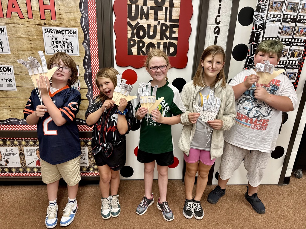 Students in Mrs. Dennison's class displaying model robot hands they created.