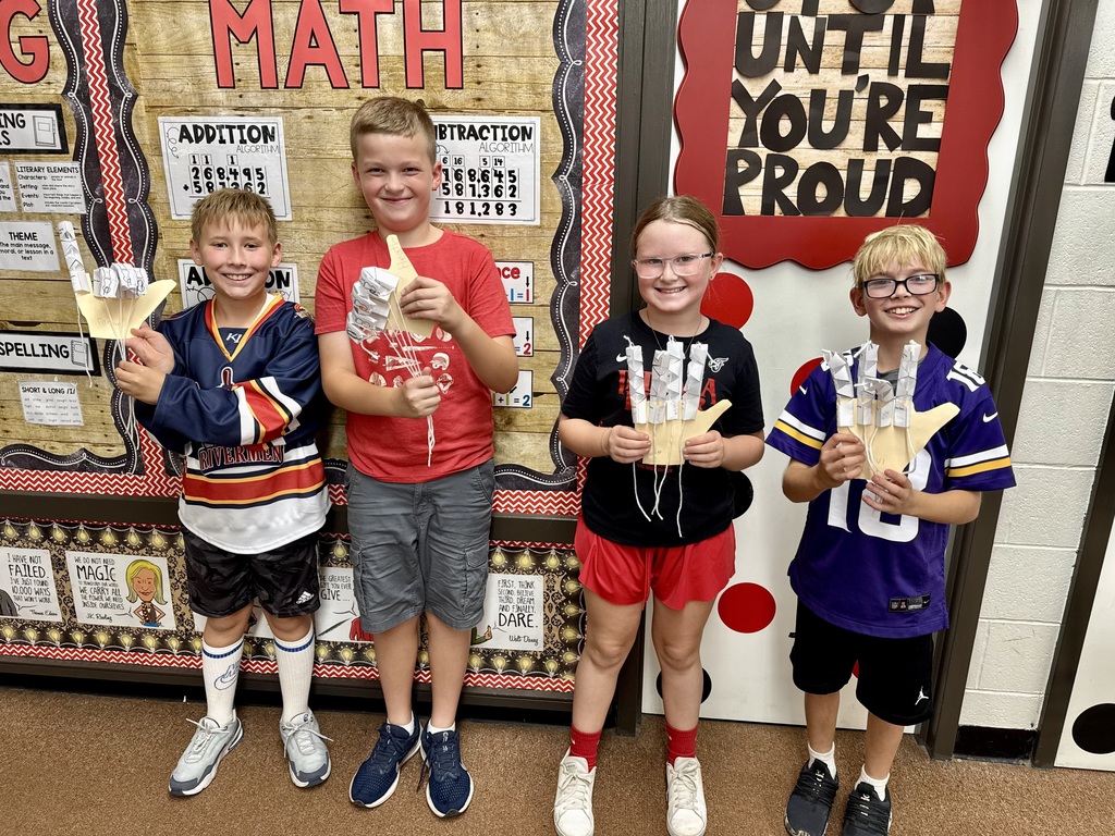 Students in Mrs. Dennison's class displaying model robot hands they created.