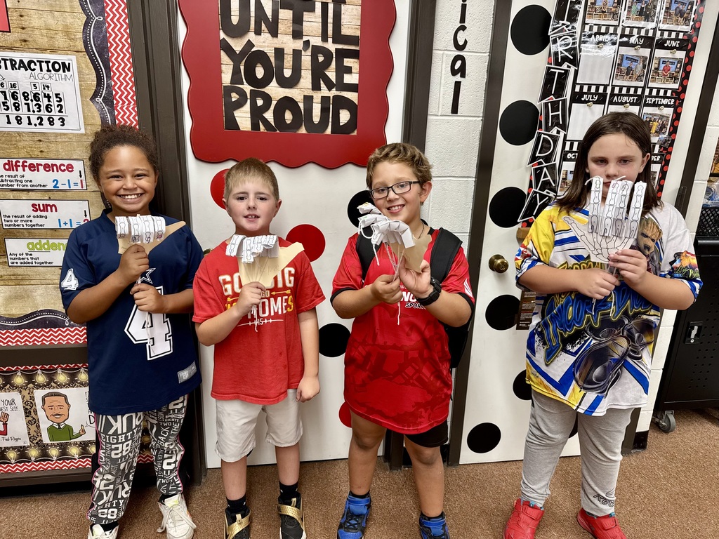 Students in Mrs. Dennison's class displaying model robot hands they created.