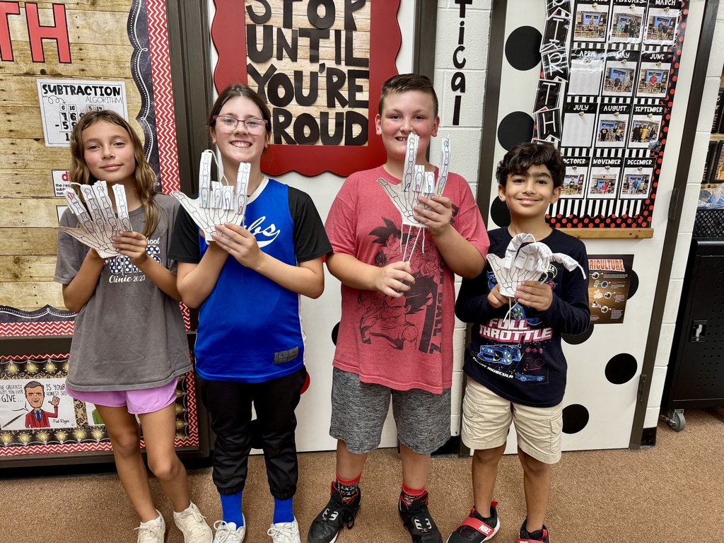 Students in Mrs. Dennison's class displaying model robot hands they created.