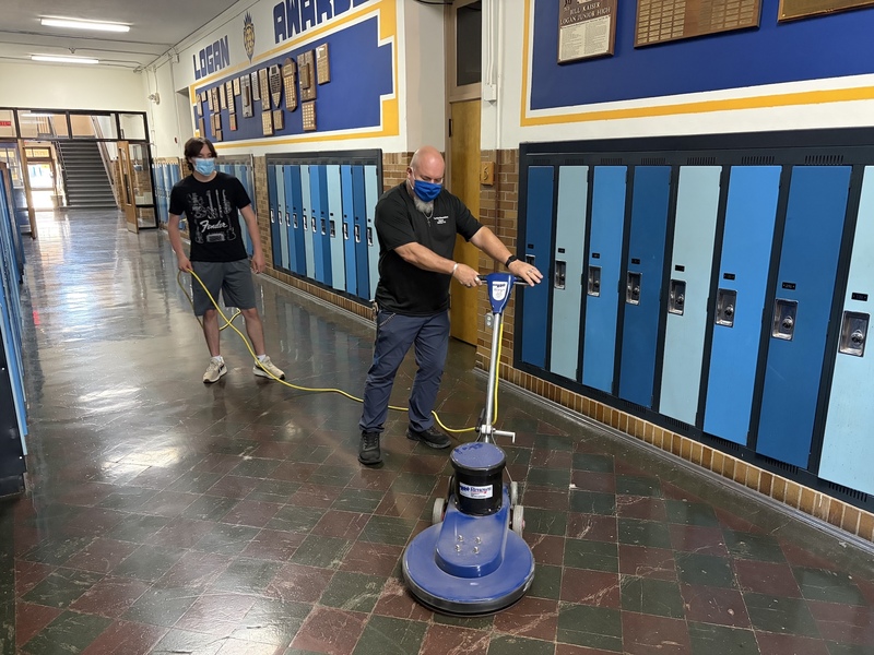 Custodians cleaning hallway floor