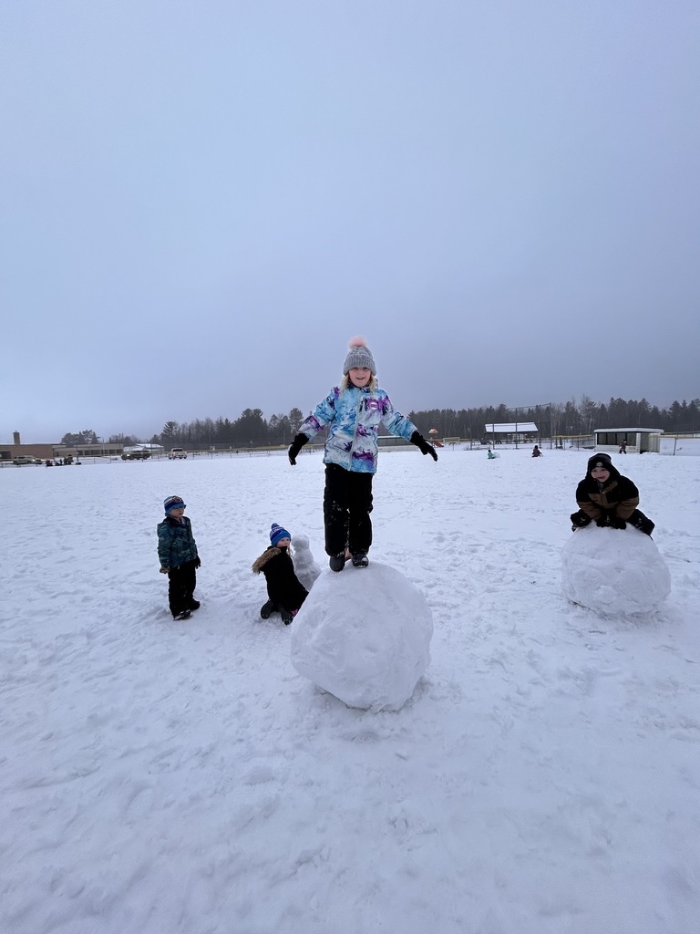 Group of kids standing on top of their large snow balls