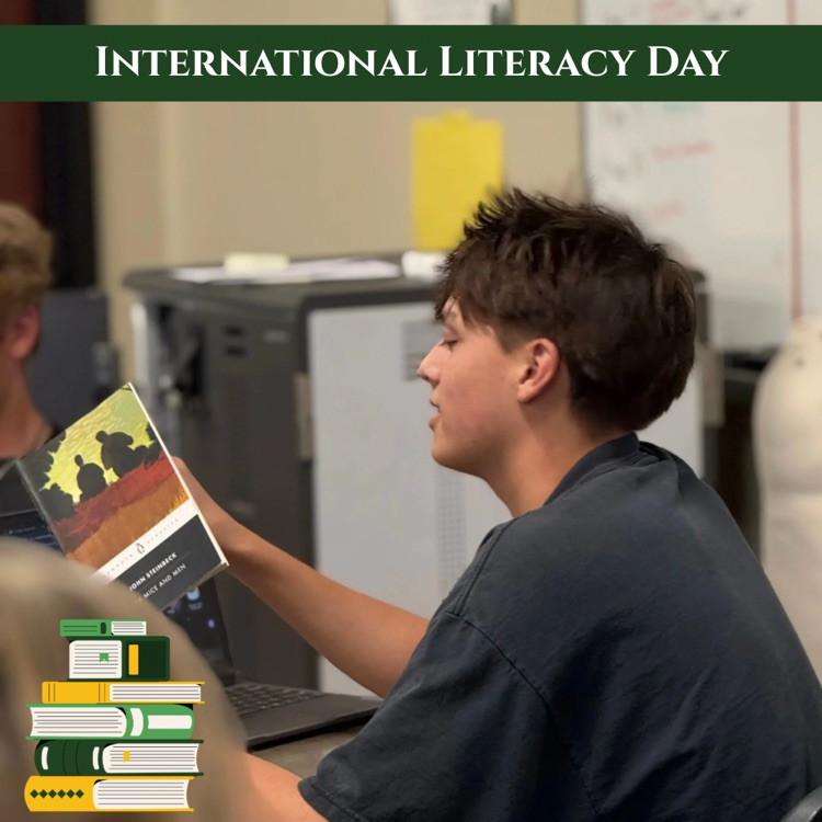 Junior Chase Serrecchia reads Of Mice and Men during class. Graphic banner says International Literacy Day with a stack of books in the bottom left corner. 