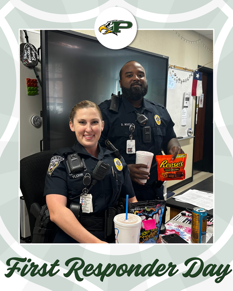 Officer Flohr and Officer Noiel, Prosper ISD police officers, smile in a classroom. Officer Flohr is seated with a large drink and candy on the desk, while Officer Noiel stands holding a Reese’s bag. Both are in uniform with radios and badges. A Texas flag and whiteboard are in the background.