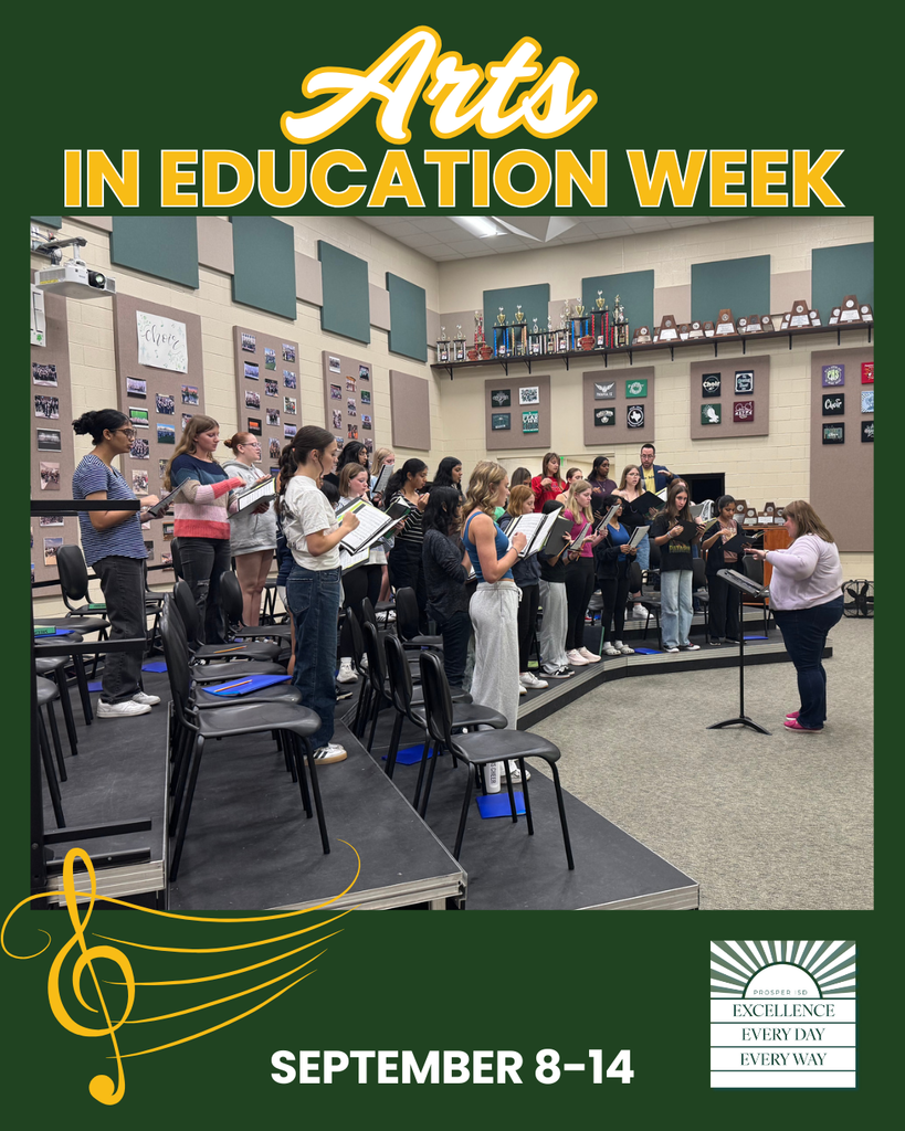 Choir students rehearse in a music classroom, standing on risers with open folders as they sing. A teacher directs from the front of the class. The background shows trophies and framed pictures.