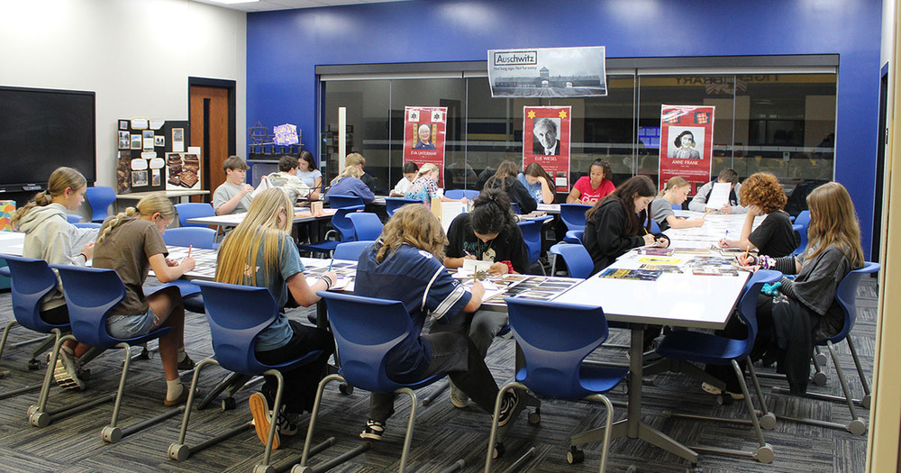 students sitting at tables writing