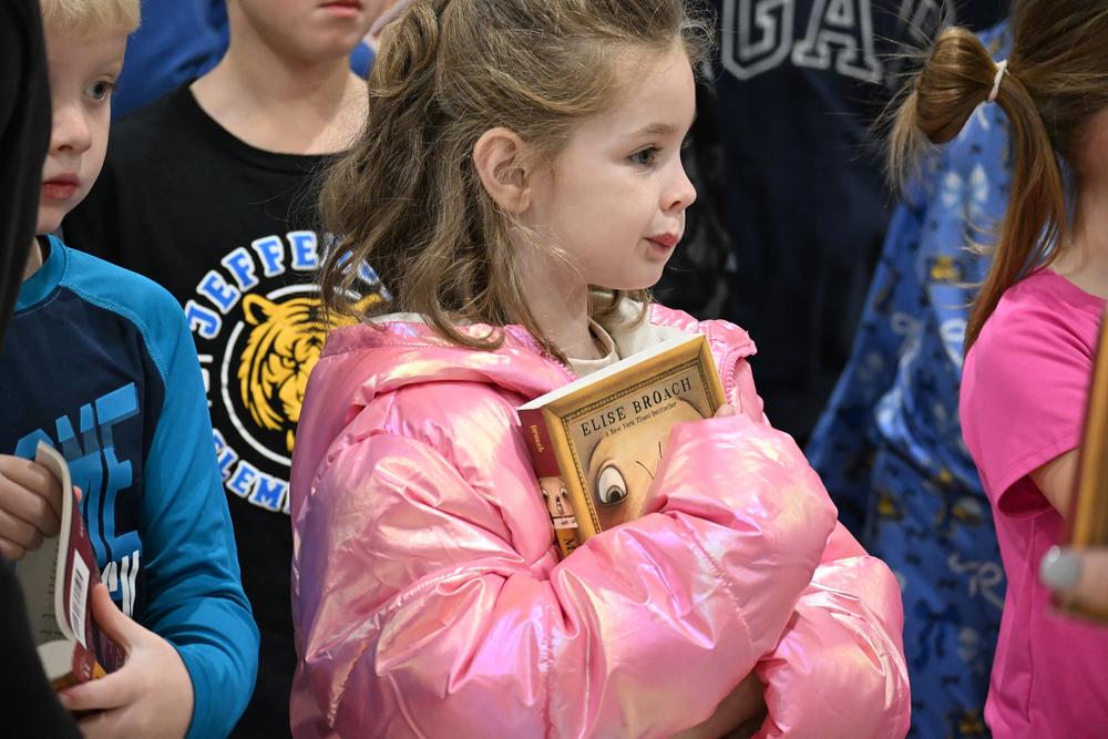 little girl holding book