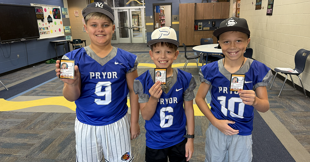 three boys holding cards