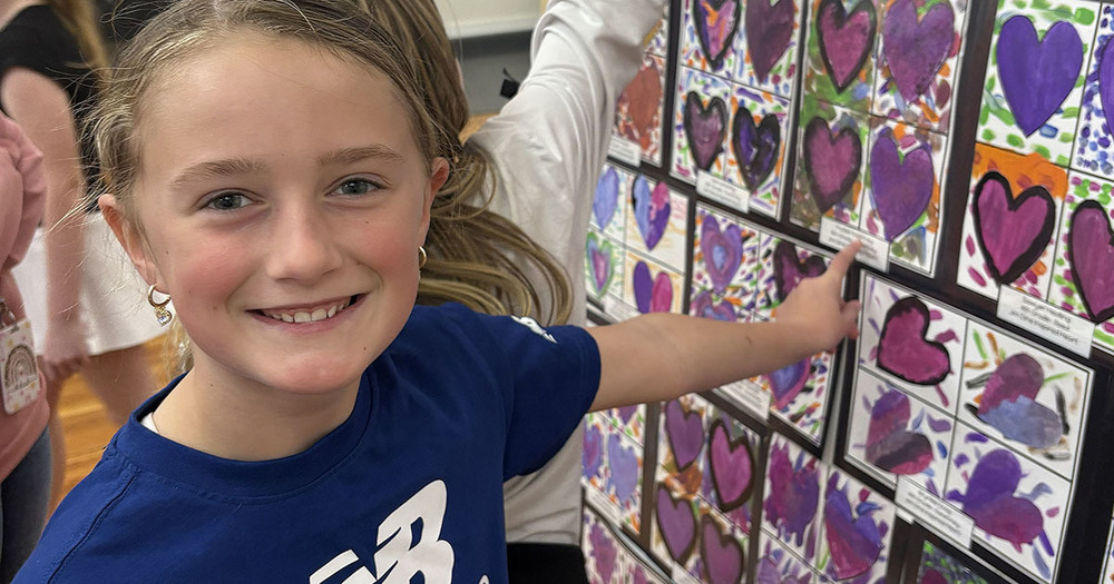 little girl points to her art