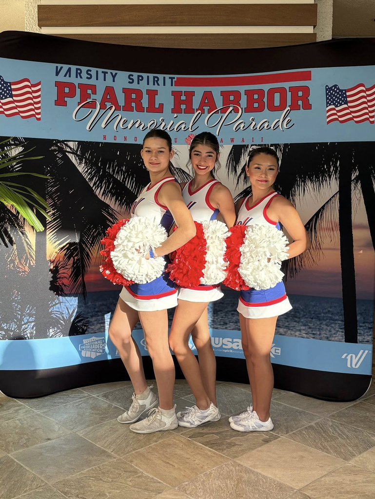 three cheerleaders in front of pearl harbor sign