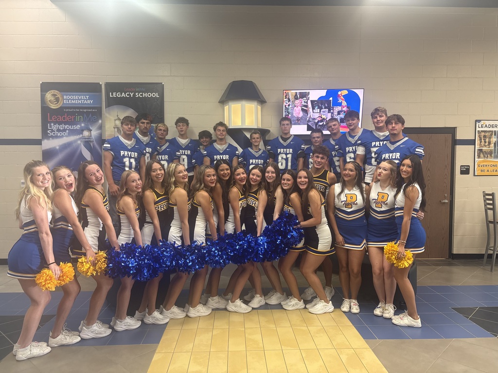 Group of cheerleaders and football players posing for picture lighthouse background