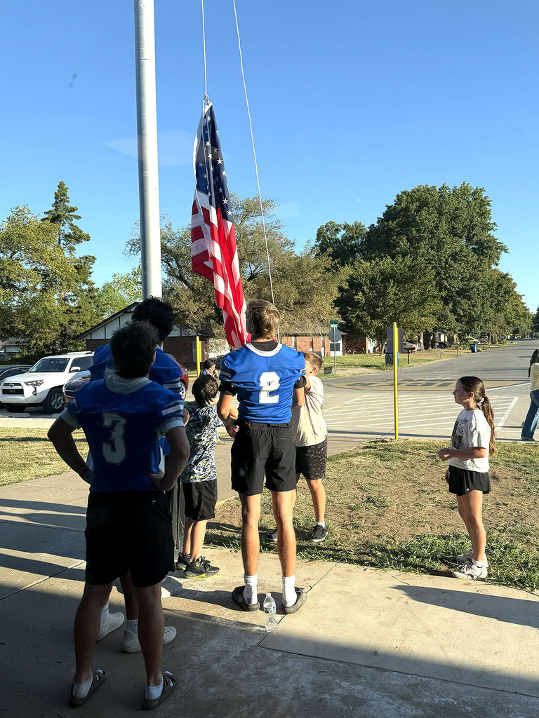 students raising flag