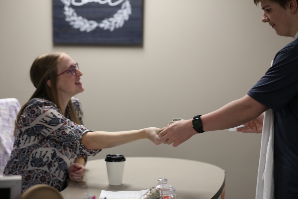 Teacher giving student money for the coffee
