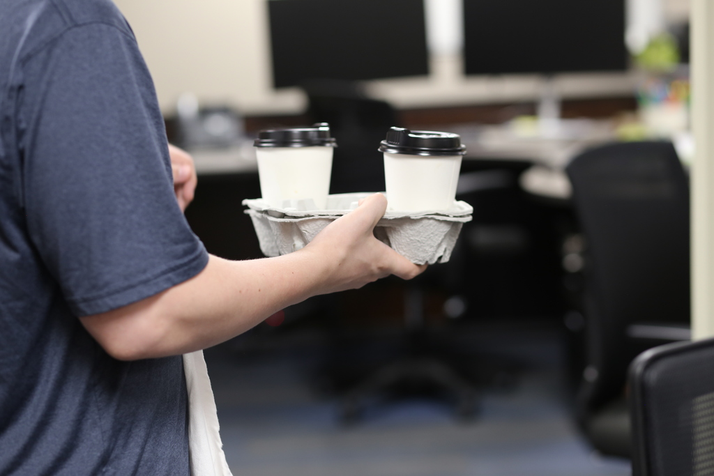 Cub holder tray of two coffees holed by a student
