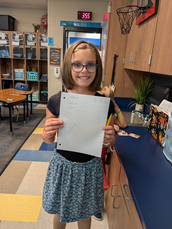 girl holding algebra paper