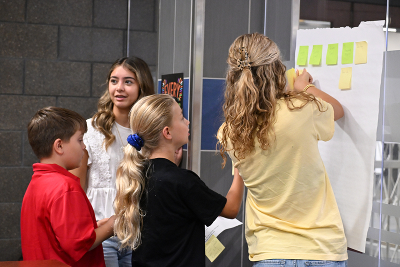students writing on poster