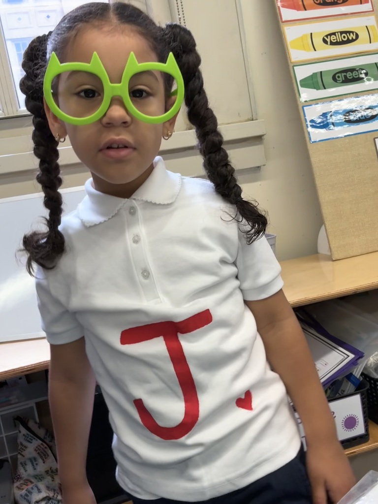 Child wearing a shirt with a letter on it, for "Scrabble Day"