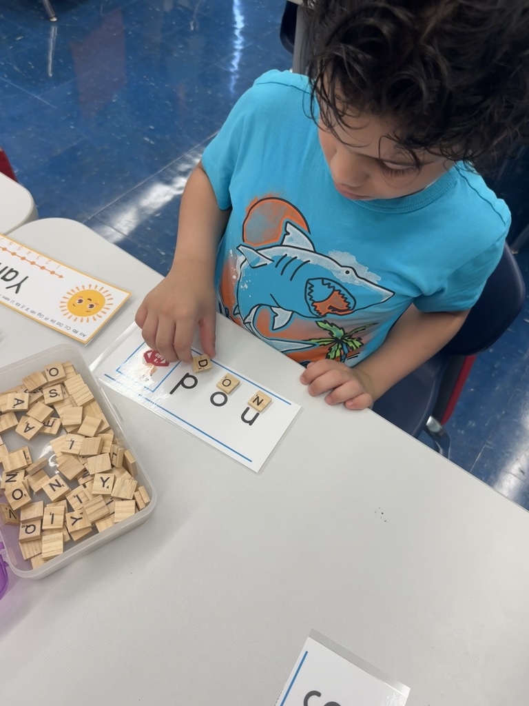 Child using Scrabble tiles to spell a word