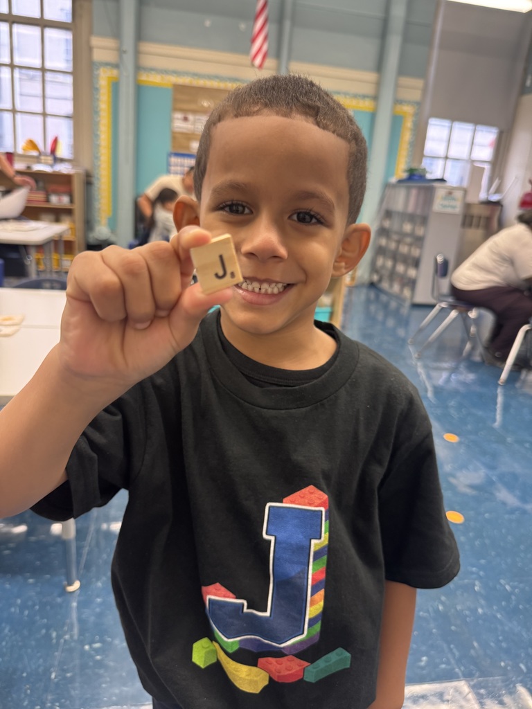 Child holding a Scrabble tile
